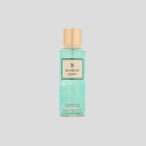 A 250ml bottle of Victoria's Secret Seaside Surf Fragrance Mist, featuring a sleek transparent bottle with ocean-inspired design elements. The mist is light blue in color, evoking the feeling of a cool sea breeze. The label showcases beachy patterns, and the bottle is displayed against a bright, airy background to enhance its fresh, summery appeal.