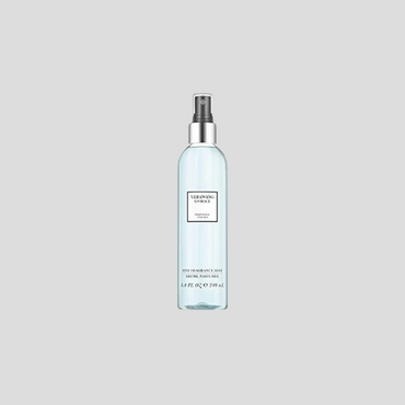 A 240ml bottle of Vera Wang Embrace Periwinkle and Iris Perfume Fragrance Mist, showcasing a delicate, transparent bottle with floral design elements. The mist is a soft, pale color, reflecting the light and fresh nature of the fragrance. The label features the Vera Wang logo and product name, set against a subtle floral background that enhances its elegance and charm.

